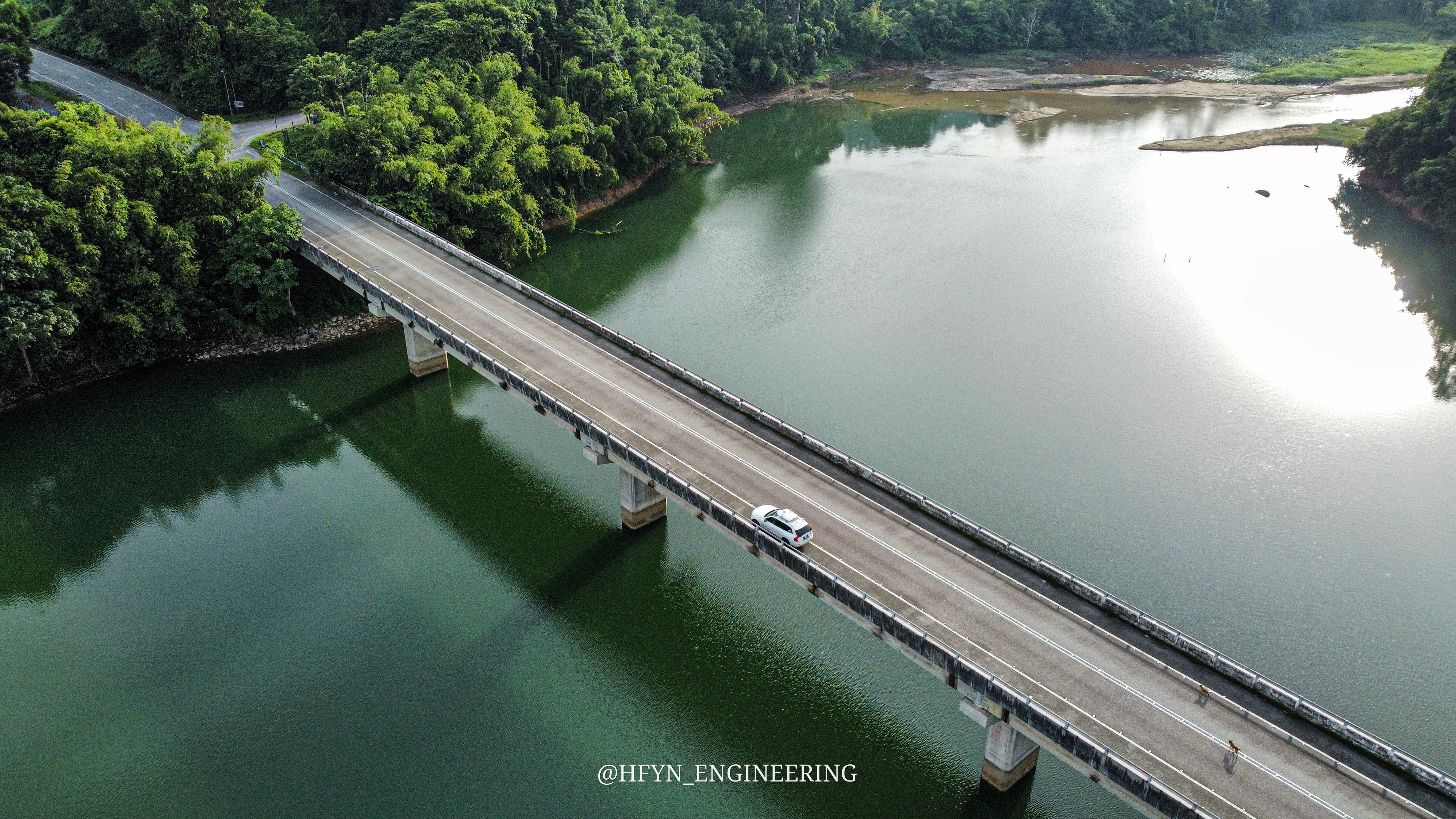 Aerial view of a test vehicle crossing a bridge over a reservoir