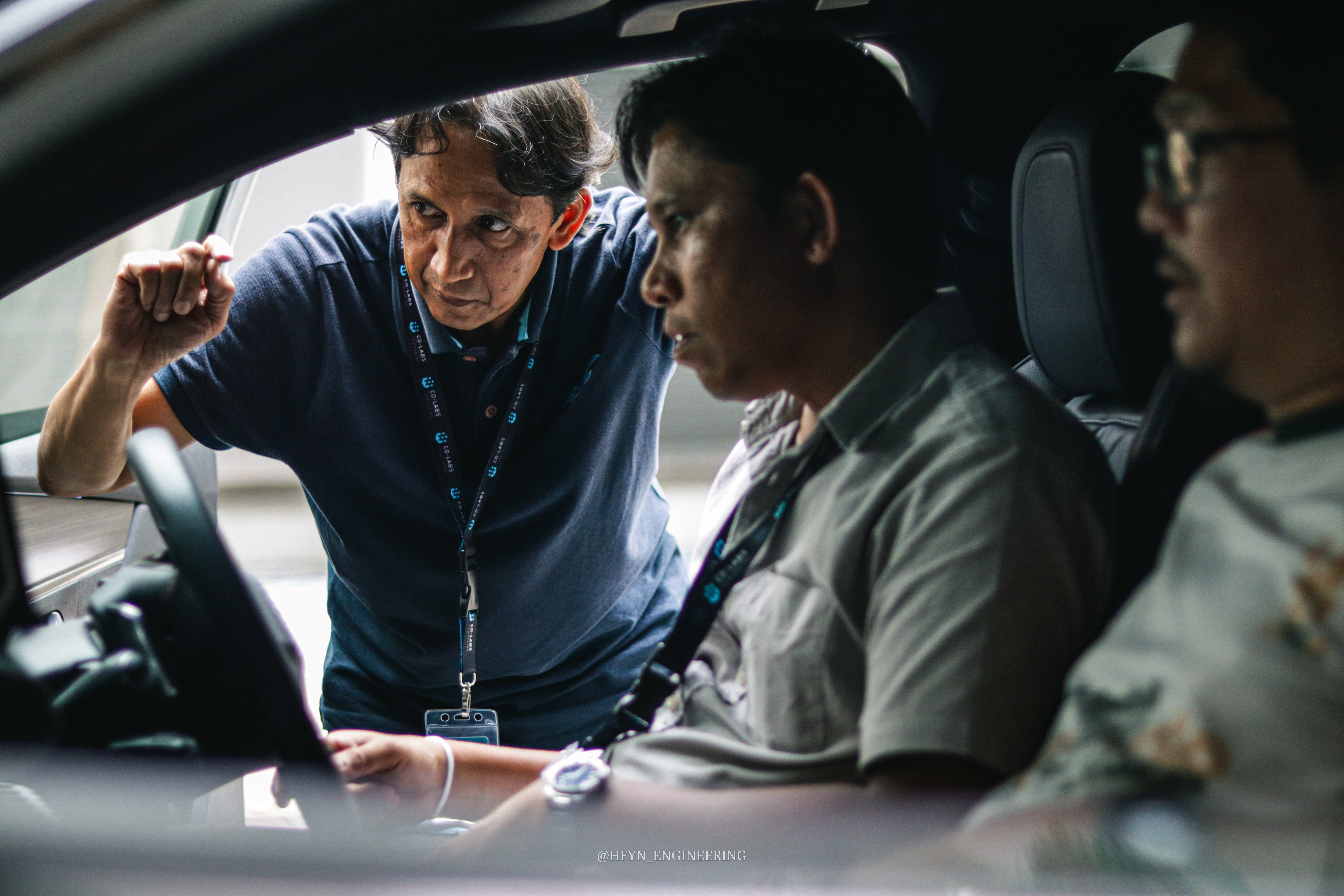 An engineer coaching drivers through a vehicle's controls