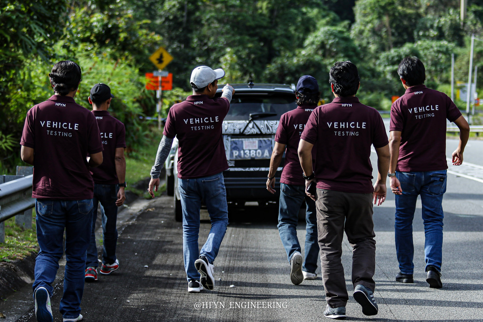 A team in HFYN uniforms walking to a camouflaged test vehicle on the road